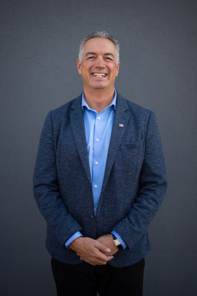 Portrait of Dan Cantillana smiling in a blue blazer